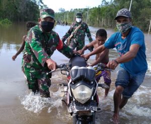 TNI Dan Polri Bantu Masyarakat Yang Kendaraannya Terjebak Banjir di Trans Papua